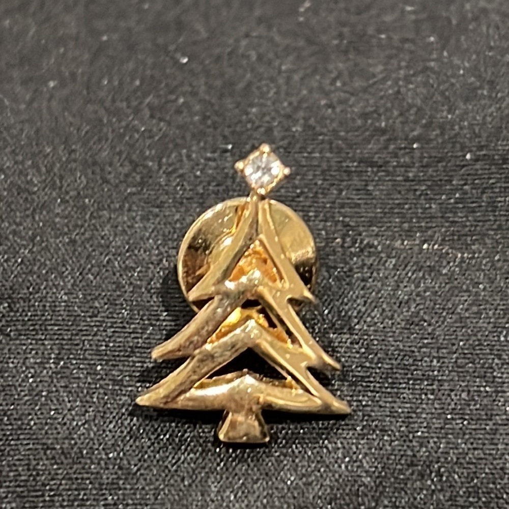 Vintage, signed AVON Christmas tree pin with a clear rhinestone at the top.